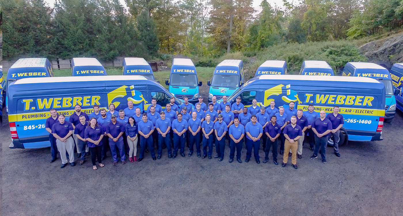 A photo of the T.Webber staff in front of their trucks.